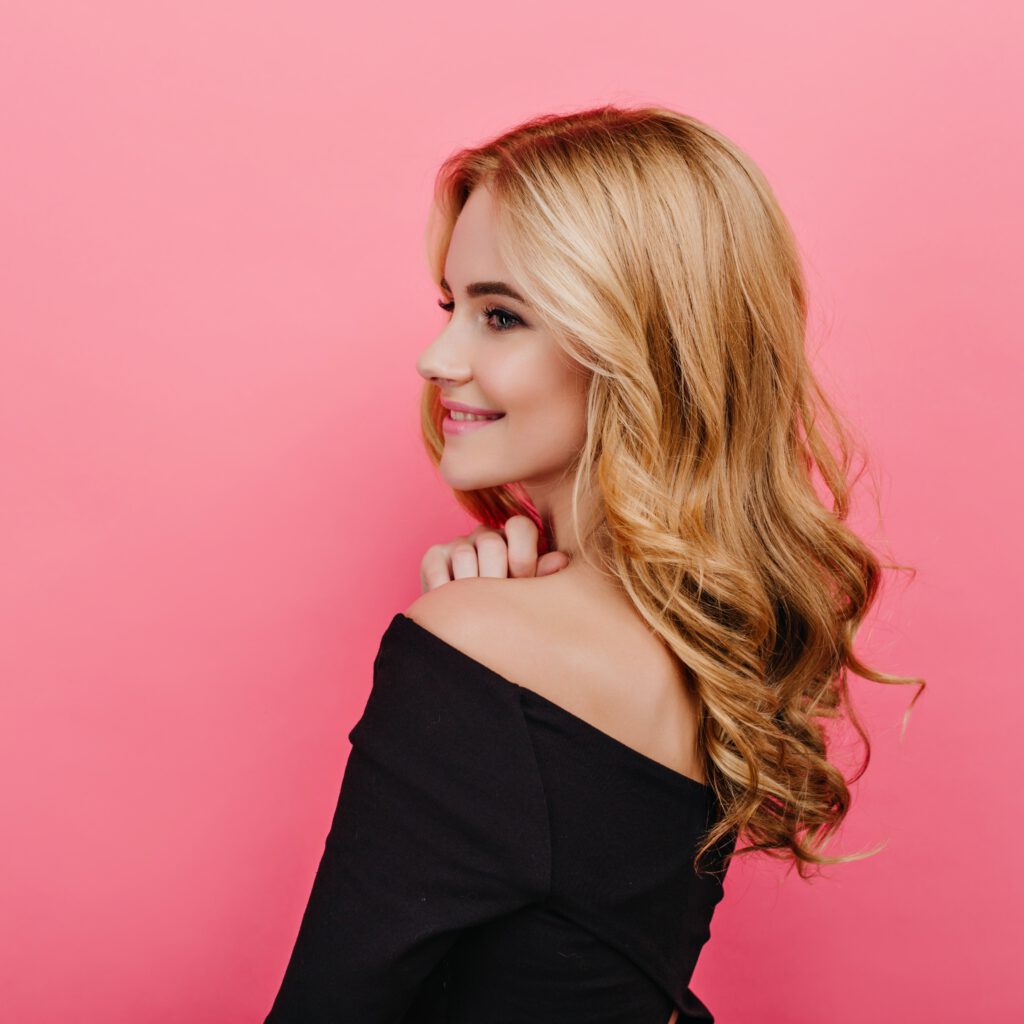 wonderful-pale-girl-with-elegant-curly-hairstyle-looking-away-shot-from-back-pleased-fair-haired-woman-black-clothes-min